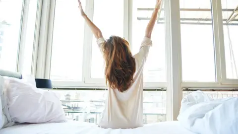 Getty Images A woman waking up early