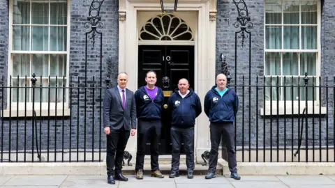 Rory Arnold/No 10 Downing Street The 3 Dads outside the front door of 10 Downing Street alongside Penrith and the Border MP Neil Hudson