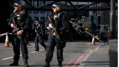 Getty Images Armed police officers stand near the location where the attacker's van crashed, on London Bridge