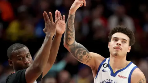 Lester Quinones celebrates a three-point basket for the Golden State Warriors
