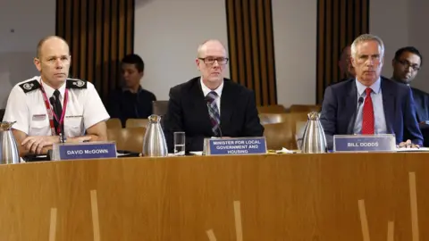 Andrew Cowan David McGown, of SFRS, Housing Minister Kevin Stewart and government head of building standards Bill Dodds