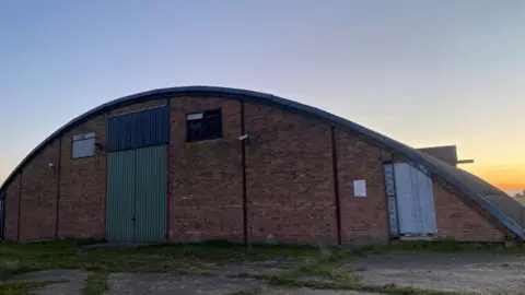 John Fairhall/BBC A building on an airfield