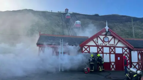 Paul Waugh Smoke seen billowing from railway's building on cliffside