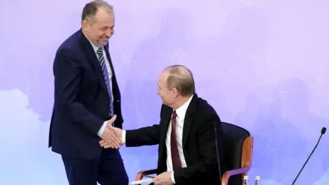 PA Media Vladimir Lisin (L) shaking hands with Russia's President Vladimir Putin (R) during a meeting of the Russian Union of Industrialists and Entrepreneurs in 2017