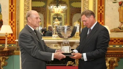 Getty Images Prince Philip handing Sir David the Aero Club Cup at Buckingham Palace in June 2011