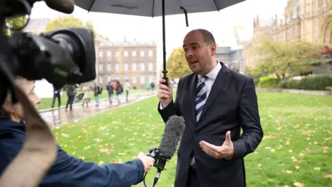 Getty Images Richard Holden MP being interviewed by media