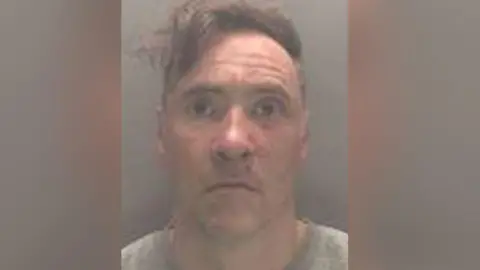 CPS A mugshot of Paul Doyle wearing a grew jumper looking stunned.