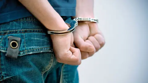 Getty Images Young man in handcuffs