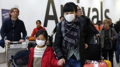 EPA Passengers arrive wearing a mask at Terminal 4, Heathrow Airport, London, Britain, 22 January 2020.