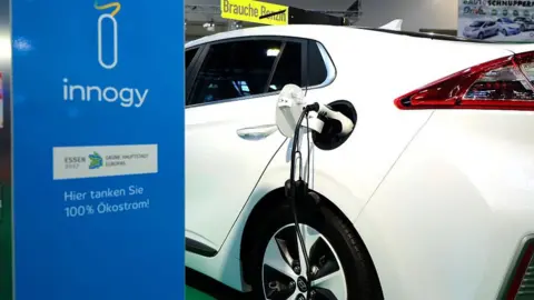 EPA An electric car connects with a charger during a motor show in the western German city of Essen