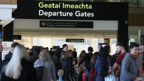 PA People gathering at the entrance to the departure gates area at Dublin Airport