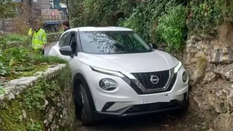 Christopher Mann White Nissan Juke wedged in the footpath