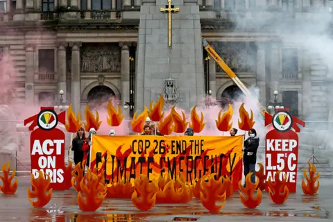 Russell Cheyne / Reuters Activists in Glasgow, Scotland, symbolically set George Square on fire with an art installation of faux flames and smoke ahead of the UN climate conference (COP26) on 28 October 2021