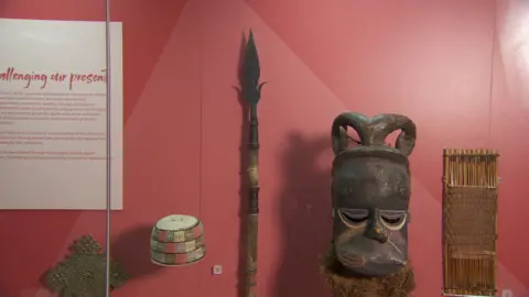 BBC Ulster Museum display of artefacts including spear it says was taken from Benin in 1897