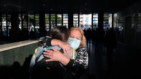 Getty Images A mother and daughter embrace after the arrival of the first high-speed train connecting Turin and Reggio Calabria