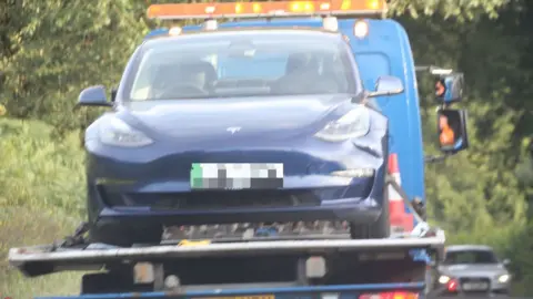 Eddie Mitchell A Tesla is taken away from the crash scene