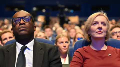 Getty Images Kwasi Kwarteng sitting next to Liz Truss at the Tory Conference