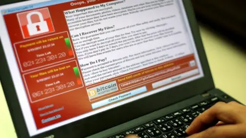 EPA A programmer shows a sample of the WannaCry locked encryption page on a laptop