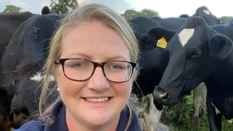 Lindsey Isgar in front of some cows