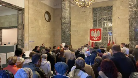 Voters queue at a polling station in Poland