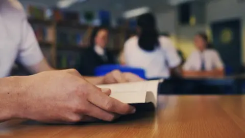 Gemma Laister Pupil holds a book in a school library