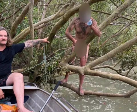 Cam Faust A fugitive who was found clinging to mangroves near Darwin, Australia drinks a bottle of water