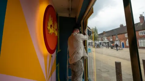 Global Street Art Artist at work in a shop window