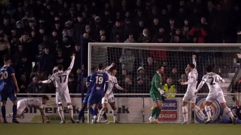 Adam Davy Newport County's James Clarke (on the ground) scores their side's second goal of the game during the Emirates FA Cup third round replay match at the Silverlake Stadium, Eastleigh