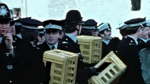 AFP Police officers defend themselves with milk crates