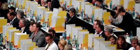 AFP/Getty Delegates vote behind portable cardboard voting cabins during a congress of Germany's conservative Christian Democratic Union (CDU) party on December 7, 2018 at a fair hall in Hamburg