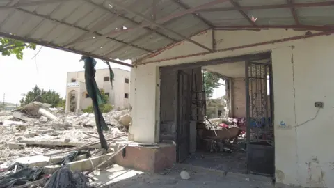 The entrance of a building surrounded by rubble