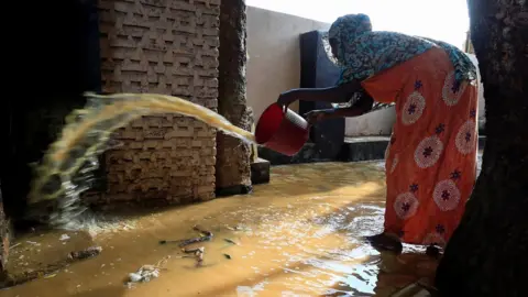 Reuters A resident pours out the waters of the Blue Nile floods from her backyard within the Al-Ikmayr area of Omdurman in Khartoum