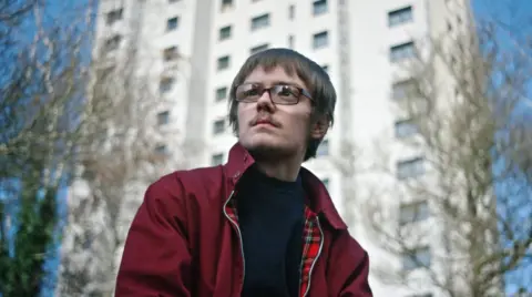 BBC Anthony in front of flats in Nottingham