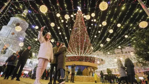 EPA Ukrainians take a selfie with Kyiv's main Christmas tree