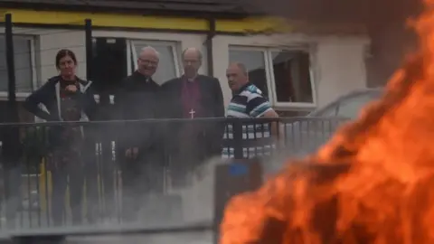 Diocese of Derry and Raphoe Bishops looking at van on fire.