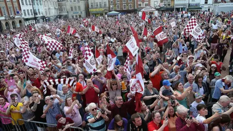 Getty Images A crowd of people, many wearing Cobblers scarves