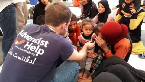 UNHCR/Amira Abd El Khalak Workers at camp check children's health