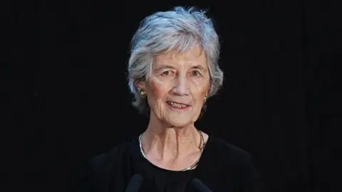 PA Media Catherine Connolly, a woman with grey hair and black clothing, standing at a podium.