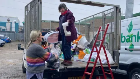 Michaela Martindale Two people unloading items at a Baby Bank in Bedford