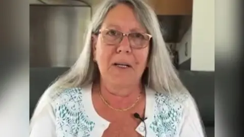 Woman with long fair hair and glasses