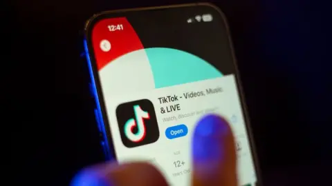 Getty Images A mobile phone user clicks to download the TikTok app