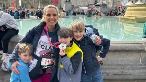 Claire Gleave Claire and her sons with her medal