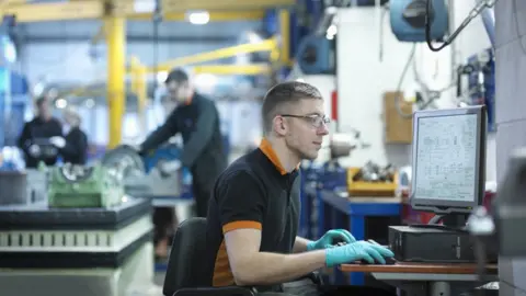 Getty Images Workers in engineering company