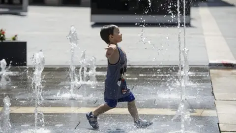 EPA A young boy runs through a fountain in Hungary