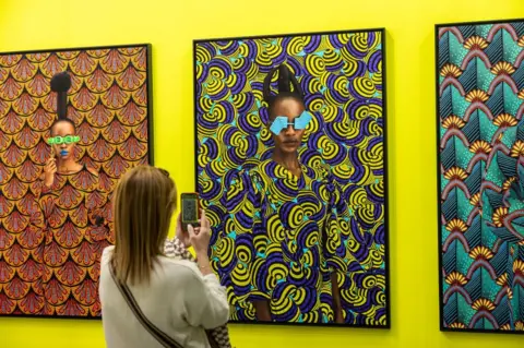 EMANUELE CREMASCHI/GETTY IMAGES A woman takes a photos of the artworks.