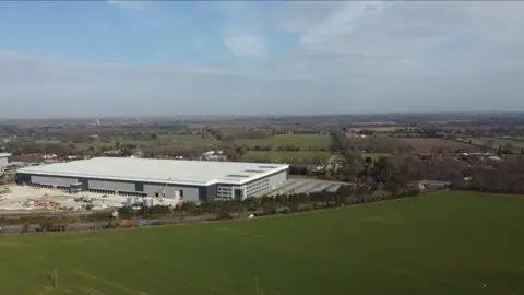 Jamie Niblock/BBC An aerial shot showing the warehouse next to large green field and in front of homes in Felixstowe Road 