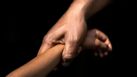 Getty Images An adult holding a child's hand