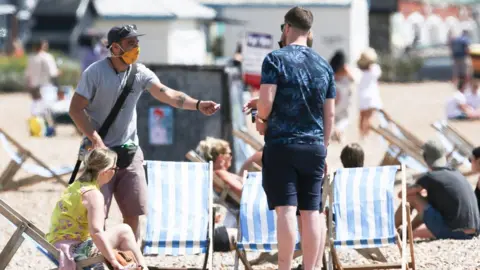 eddie mitchell People in face masks at Brighton Beach