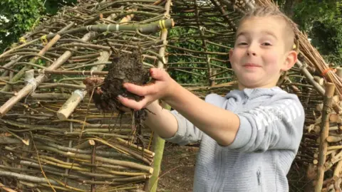 Adam Flack Logan Flack holding the wattle-and-daub