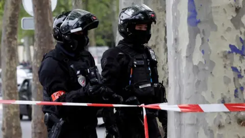 French police secure the area near Iran consulate where a man is threatening to blow himself up